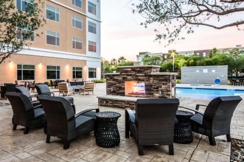 a patio with chairs and a fireplace next to a pool at Cambria Hotel McAllen Convention Center in McAllen