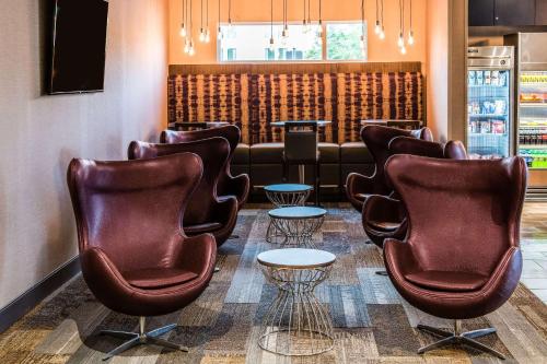 a waiting room with leather chairs and tables at Cambria Hotel McAllen Convention Center in McAllen