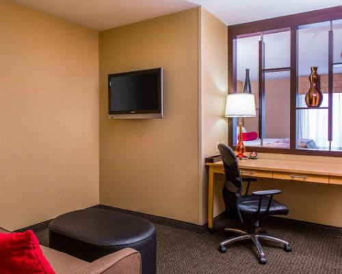 a hotel room with a desk with a computer and a chair at Cambria Hotel Appleton in Appleton