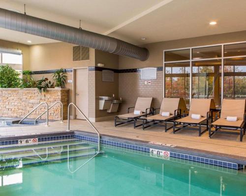 a pool at a hotel with chairs and a table at Cambria Hotel Appleton in Appleton
