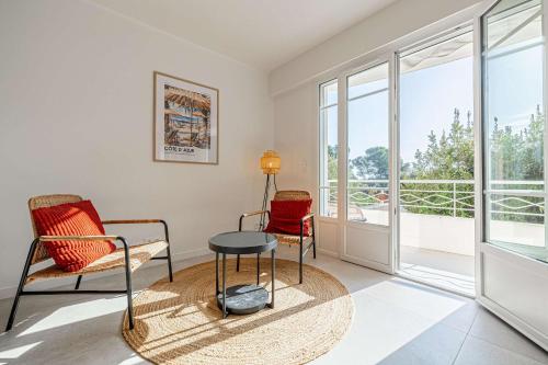 un salon avec deux chaises et une table dans l'établissement LE GRAND BOIS élégant et chaleureux avec balcon, au calme et à deux pas du centre-ville, à Cannes