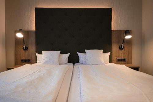 a bedroom with a large bed with two white pillows at Spundloch- das Hotel & Weinrestaurant in Veitshöchheim