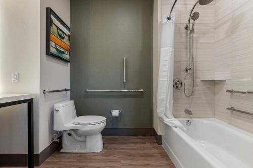 a bathroom with a toilet and a tub and a shower at Cambria Hotel - Arundel Mills BWI Airport in Hanover