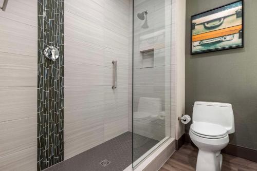 a bathroom with a toilet and a glass shower at Cambria Hotel - Arundel Mills BWI Airport in Hanover