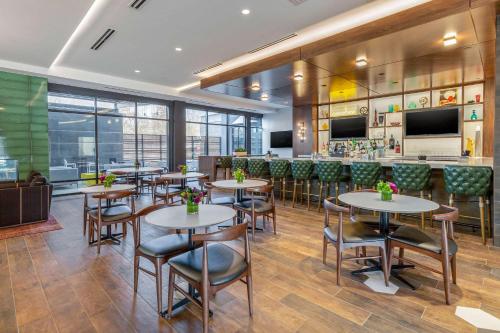 a restaurant with tables and chairs and a bar at Cambria Hotel - Arundel Mills BWI Airport in Hanover