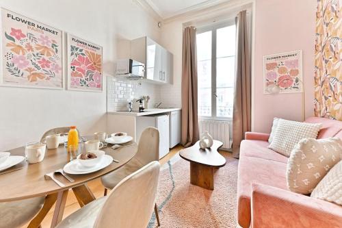 - un salon avec une table et un canapé rose dans l'établissement Magnifique appartement Neuf Rose Paris 14ème - II, à Paris