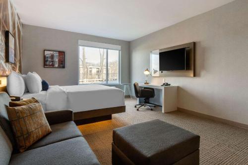 a large hotel room with a bed and a desk at Cambria Hotel West Orange in West Orange