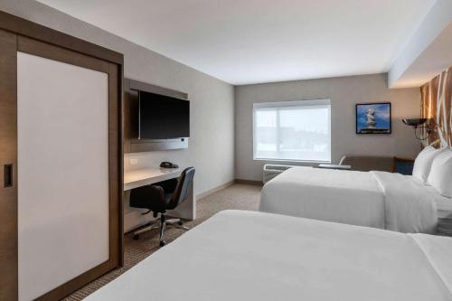 a hotel room with two beds and a desk at Cambria Hotel West Orange in West Orange