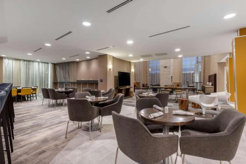 a restaurant with chairs and tables in a room at Cambria Hotel West Orange in West Orange