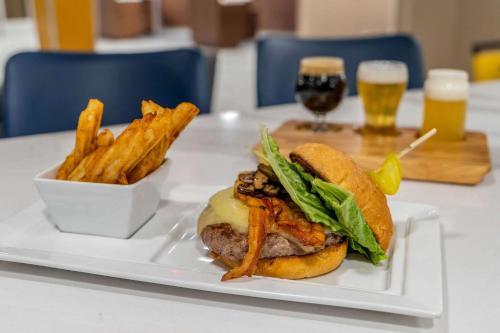 a white plate with a sandwich and french fries at Cambria Hotel West Orange in West Orange