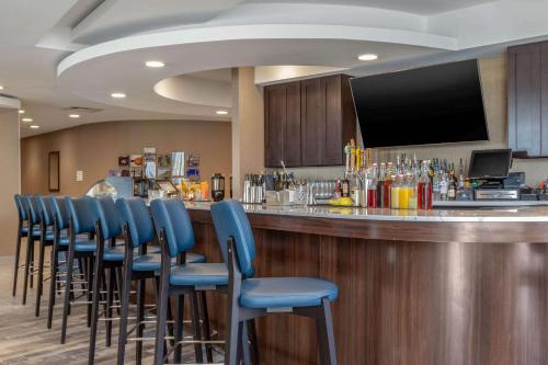 a bar with blue chairs and a flat screen tv at Cambria Hotel West Orange in West Orange