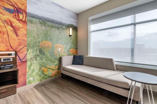 a living room with a couch and a window at Cambria Hotel Bloomington Mall of America Minneapolis Airport in Bloomington