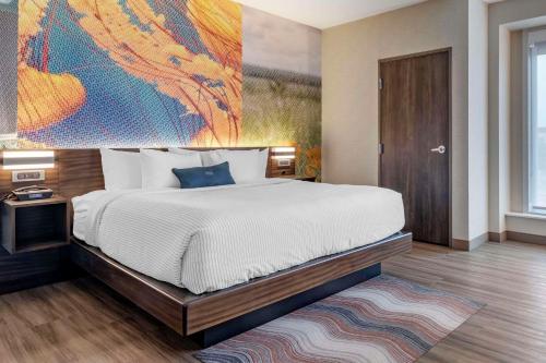 a bedroom with a bed with a large painting on the wall at Cambria Hotel Bloomington Mall of America Minneapolis Airport in Bloomington