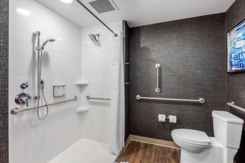 a bathroom with a shower and a toilet at Cambria Hotel Milwaukee Downtown in Milwaukee