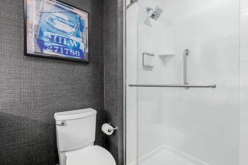 a bathroom with a white toilet and a shower at Cambria Hotel Milwaukee Downtown in Milwaukee