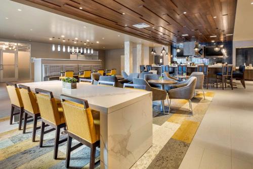 a restaurant with a large table and chairs at Cambria Hotel Milwaukee Downtown in Milwaukee