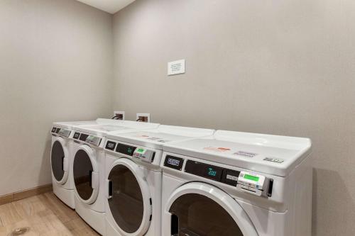 a laundry room with two washing machines in it at Cambria Hotel Plano - Richardson Garland in Richardson