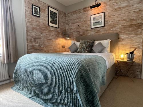 a bedroom with a bed with a wooden wall at New Flying Horse Inn in Wye