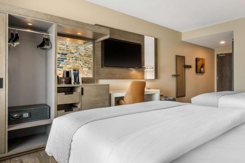 a hotel room with a large white bed and a television at Cambria Hotel Fort Mill in Fort Mill