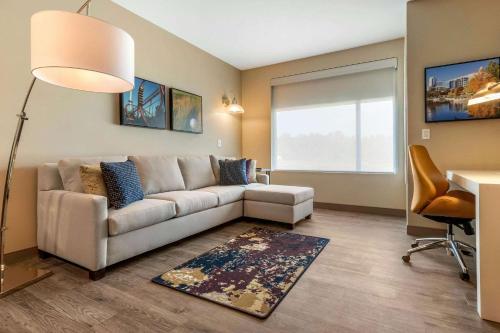 a living room with a couch and a table at Cambria Hotel Fort Mill in Fort Mill