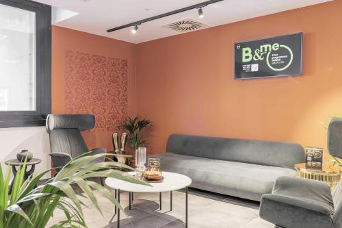 プラートにあるB&B HOTEL Prato City Centerのソファとテーブルのあるリビングルーム