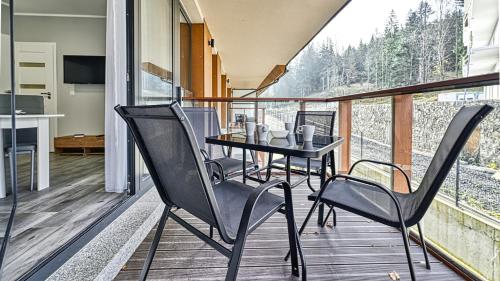 a balcony with a table and chairs on it at Źródło Izery przy gondoli VIP Sauna, Siłownia, Bawialnia by Royal Aparts in Świeradów-Zdrój