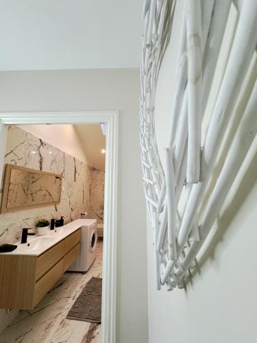 La salle de bains est pourvue d'un lavabo blanc et d'une baignoire. dans l'établissement Nest in Heart of Épernay, à Épernay