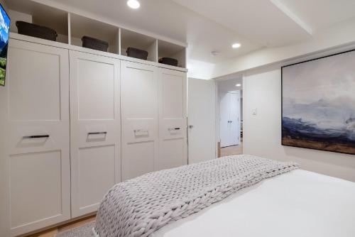 a white bedroom with white cabinets and a bed at Renovated 2 BR Aspen Condo Ski-in out in Aspen