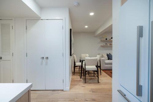 a kitchen with white walls and a dining room with a table at Renovated 2 BR Aspen Condo Ski-in out in Aspen