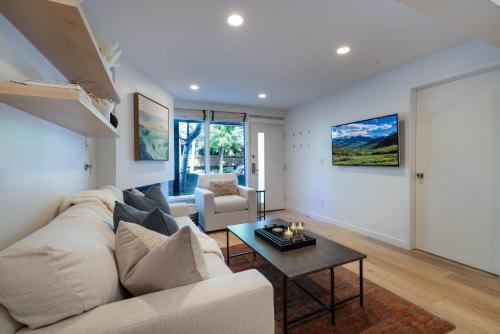 a living room with a white couch and a table at Renovated 2 BR Aspen Condo Ski-in out in Aspen