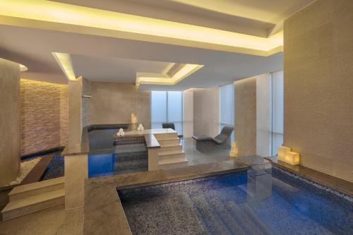 a hotel lobby with a swimming pool and stairs at Hyatt Regency Creek Heights Residences in Dubai