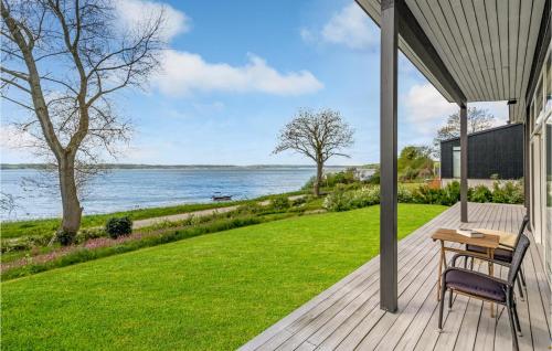 a wooden porch with a table and chairs on a lawn at 2 Bedroom Amazing Home In Aabenraa in Aabenraa