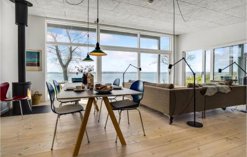 a dining room with a table and chairs and a couch at 2 Bedroom Amazing Home In Aabenraa in Aabenraa