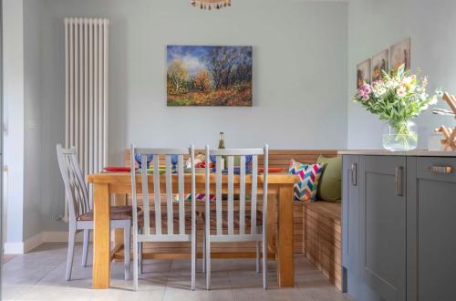 a dining room with a table and chairs and a couch at 1 Ashwood at Thoulstone Park in Westbury