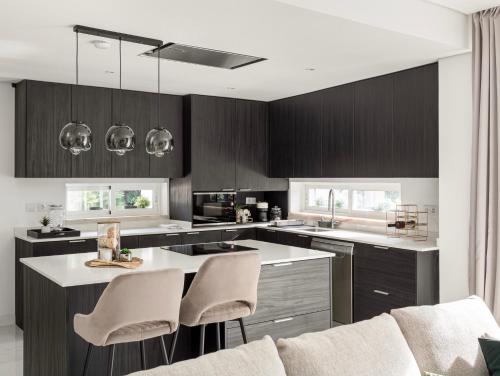 a kitchen with black cabinets and white counter tops at Santo Villa in Santo Estêvão