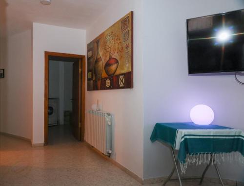 Cette chambre dispose d'une table et d'une télévision murale. dans l'établissement צימר גל 27 - צימר מקסים עם ג'קוזי מול נוף מדברי מהמם, à Arad