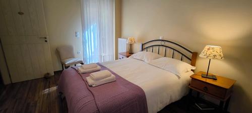 a bedroom with a large bed with two towels on it at Chalet Coquelicot (Co-cli-co) relax in nature in Kalavrita