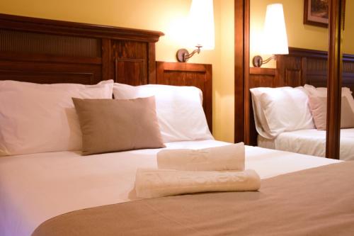a white bed with a folded towel on it at RVHotels Tuca in Vielha