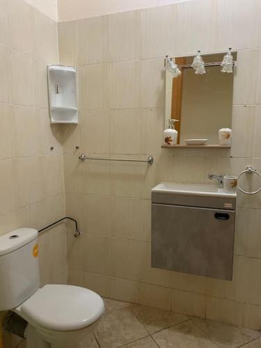 a bathroom with a toilet and a sink and a mirror at Cozy, secure and perfect for family stays in Agadir
