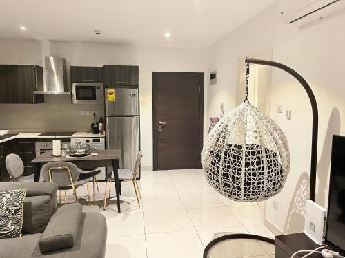 a kitchen and a living room with a chandelier at Embassy Gardens Royal Suites Apartments in Accra