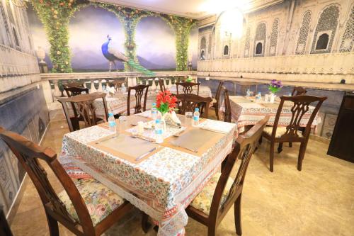 a restaurant with tables and chairs and a peacock mural at Harnawa Haveli - A Boutique Heritage Stay in Jaipur