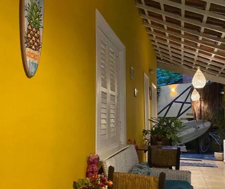 a room with a yellow wall with a white door at Canto das Laranjeiras MOA in Guarujá