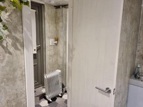 a bathroom with a door leading into a bathroom with a radiator at Studio Near Beach Garden Parking PetsOK in Sunderland