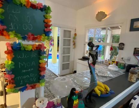 a kitchen with a counter top with a sign on it at Canto das Laranjeiras MOA in Guarujá