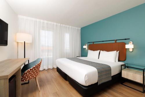 a hotel room with a bed and a desk at Exe Vienna in Vienna