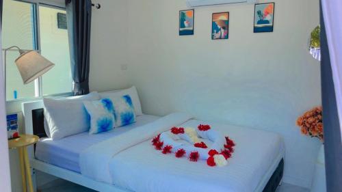 a white bed with flowers on it in a room at The White House Pakbara in Ban Pak Ba Ra