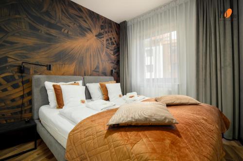 ein Schlafzimmer mit einem großen Bett und weißen Kissen in der Unterkunft Apartamenty Premium STONE HILL - Baseny&Jacuzzi in Szklarska Poręba