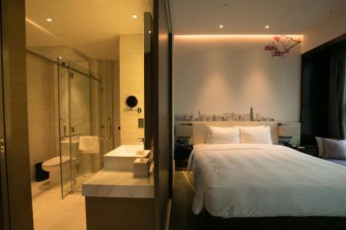 una camera da letto con un letto grande e un bagno di Hilton Garden Inn Hong Kong Mongkok a Hong Kong