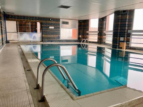 une grande piscine avec de l'eau bleue dans un immeuble dans l'établissement Le 300 by HappyNoWorry, à Paris