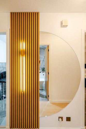 a hallway with a mirror and a room with a bathroom at The Pad in Paisley